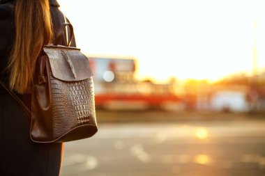 Genç esmer kadın turist otobüs otobüs durağında bekleyen bir sırt çantası ile. Boş alan