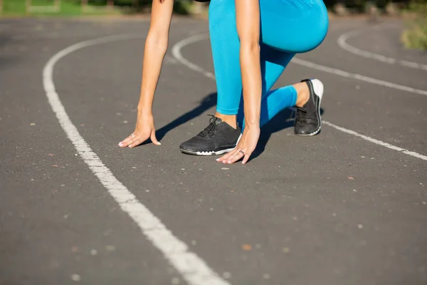 Woman runner in start position train before the race. Copy space