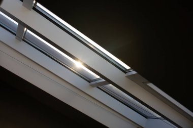 Şehir manzarası güneş ışığı ile karşı bir tavan odasında modern mansard Plastik pencere