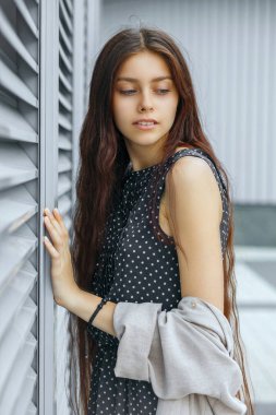 Güzel uzun saçlı esmer kadın metal panjurlar kenti yakınındaki poz