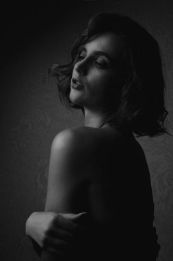 Siyah ve beyaz elbise ile dramatik ışık poz giyen güzel esmer kadın portresi