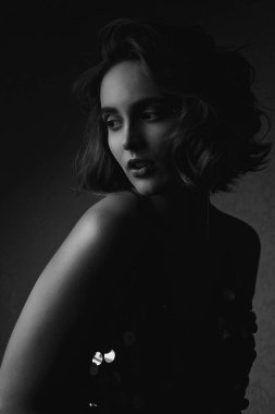 Siyah beyaz portre çekici esmer model giyen parlak elbise ile kontrast ışık poz