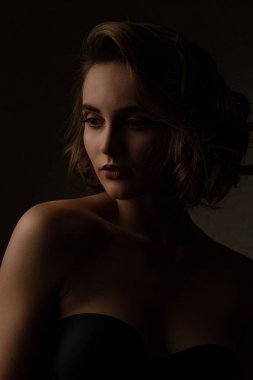 Kıvırcık saçlı esmer kadın çarpıcı karşıtlık stüdyoda ışık ile poz iç çamaşırı giyer