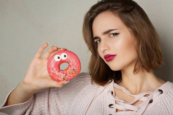 Young Suspecting Woman Natural Makeup Holding Glaze Donut Grey Background — Stock Photo, Image