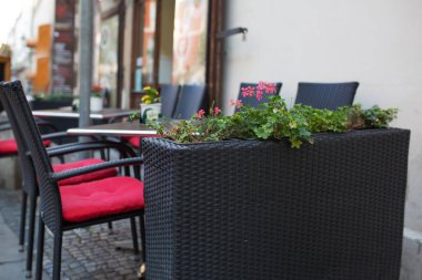 Boş hasır sandalye ve masa dışında bir sokak kafe çiçekli