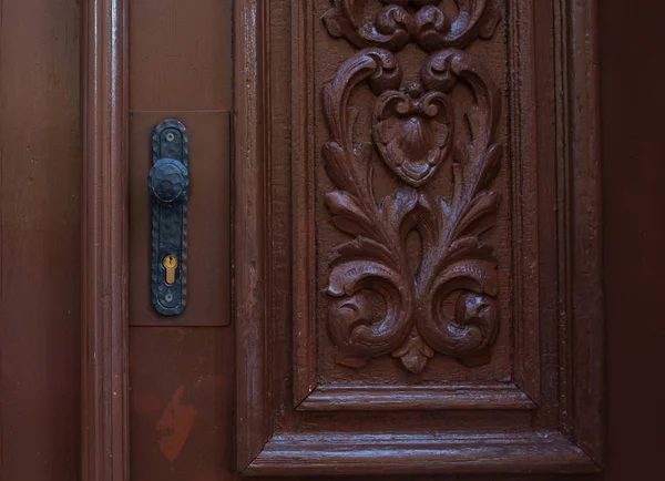 Vintage carved door with a simple handle. Closeup shot