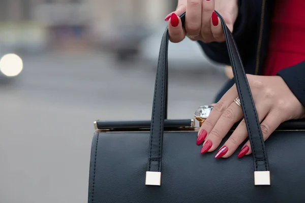 Ręka z piękny manicure czerwony otwarcie Czarna skóra pu — Zdjęcie stockowe