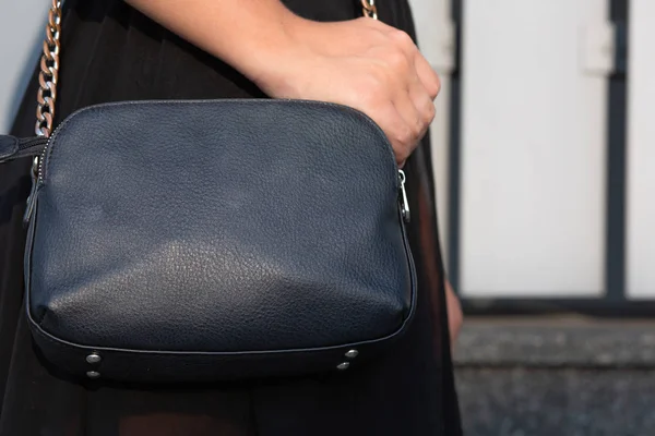 Mulher mão segurando bolsa de couro preto. Tiro de perto — Fotografia de Stock