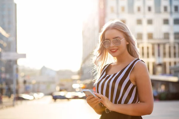 Vrolijke blonde meisje houden van mobiele telefoon bericht te typen. Ruimte — Stockfoto