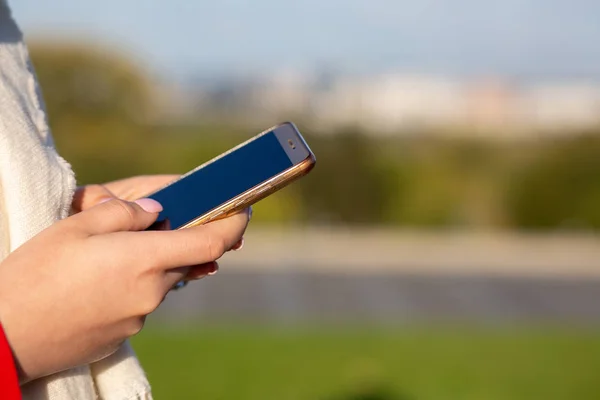 Woman using smart phone at the park in sunny day. Space for text — Stock Photo, Image