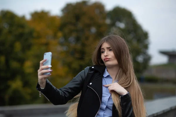Söt tjej med långt hår grimaserande och göra självporträtt på m — Stockfoto