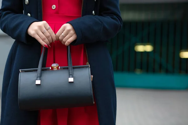 Modieus gekleed meisje bedrijf zwart lederen tas. Lege vriendelij — Stockfoto