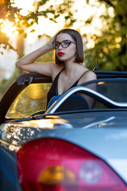 Şık model gözlük, bir Cabrio araba ile oturuyor