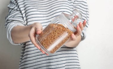 Cam storag için buğday tutan kazaklı genç kadın