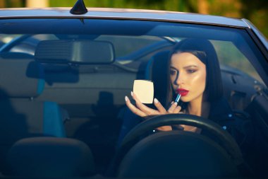 Güzel esmer kız bir Cabrio araba ile nat dudaklarında boyalar