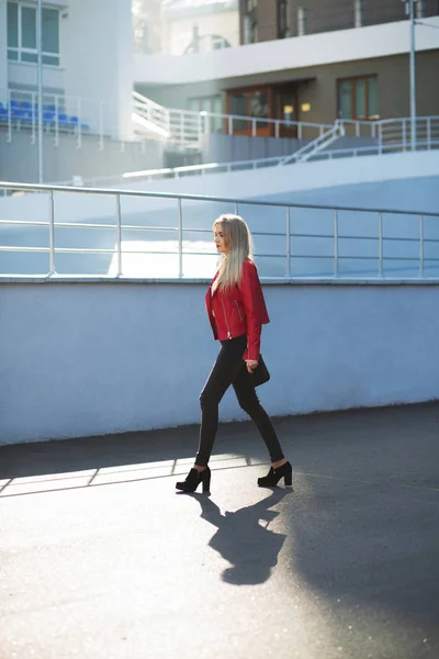 Bedövning blond modell bär röd jacka gick på gatan — Stockfoto