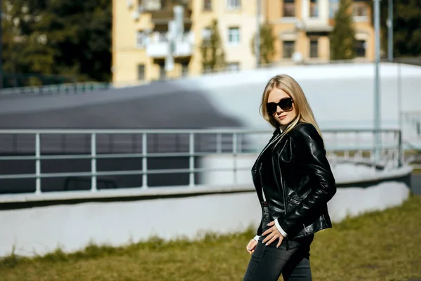 Street shot de hermosa modelo rubia con chaqueta de cuero y — Foto de Stock