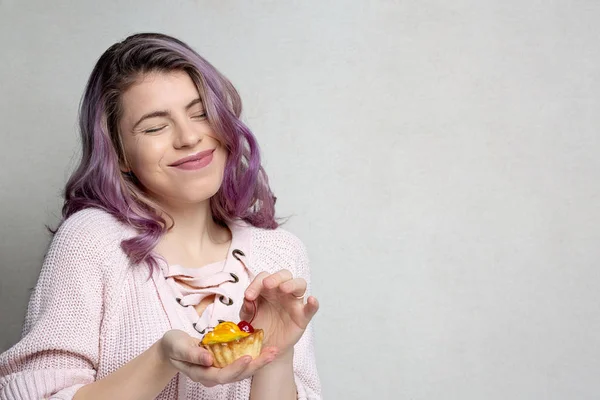 Charmante jonge meisje met paars haar genieten van lekkere dessert met — Stockfoto