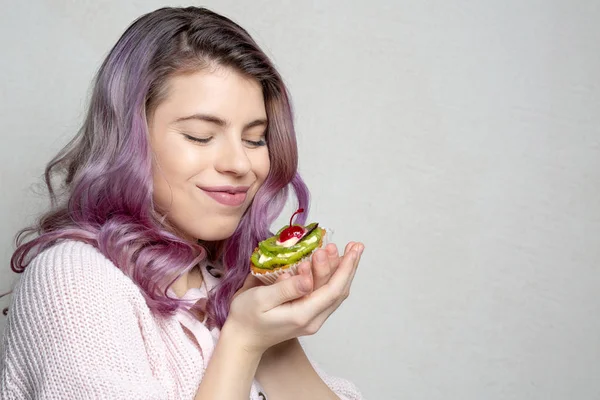 Pleased young model with purple hair enjoying tasty dessert with — Stock Photo, Image