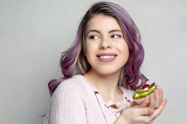 Vrolijke jonge model met paars haar genieten van lekkere dessert wit — Stockfoto