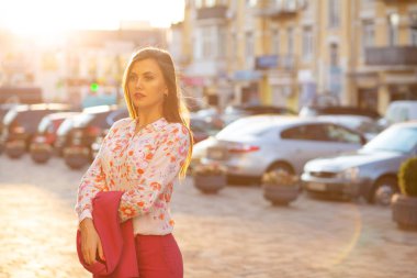 Bluz giyen ve ceket pos tutan şık esmer modeli