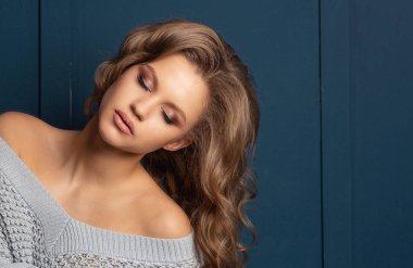 Çıplak ile kazak giyen kıvırcık saçlı sevimli sarışın model