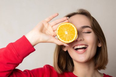 Esmer model bir e kapsayan bir yarım portakal ile poz heyecanlı