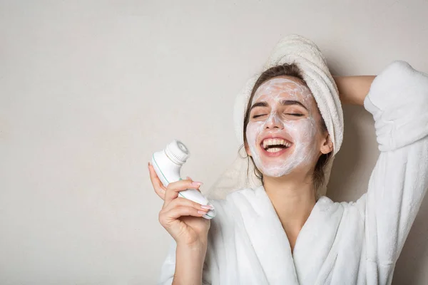 Laughing brunette girl posing with moisturizing cream mask and f — Stok Foto