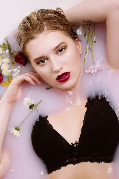 Sexy jonge vrouw in lace lingerie ontspannen in Bad met roze wat — Stockfoto