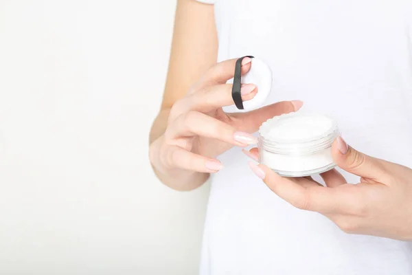 Woman holding transparent cosmetic powder over a white backgroun — Stock Photo, Image