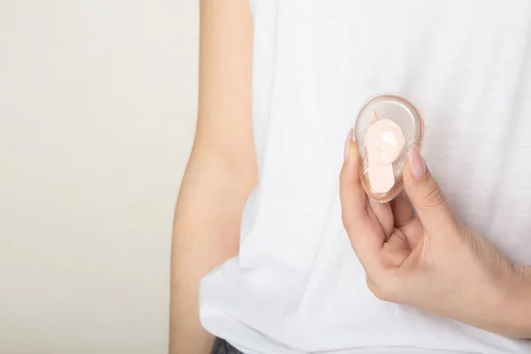 Female hand holding transparent silicone sponge with bb cream. E — Stock Photo, Image