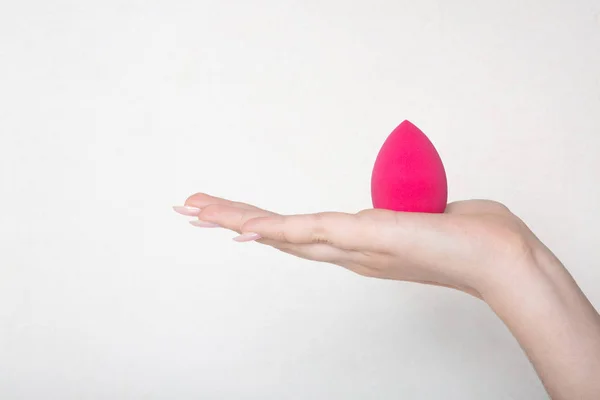 Крупный план женской руки, держащей розовый блендер над w — стоковое фото