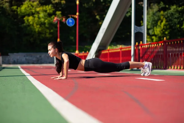 Longitud completa vista lateral de una hermosa mujer atlética haciendo push u — Foto de Stock