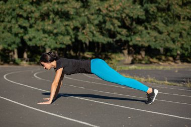 Bir tahta posi oldukça atletik bir kadının tam uzunlukta yan görünüm