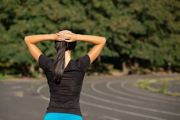 Mujer esbelta y deportiva estirándose antes de correr en el estadio. O — Foto de Stock