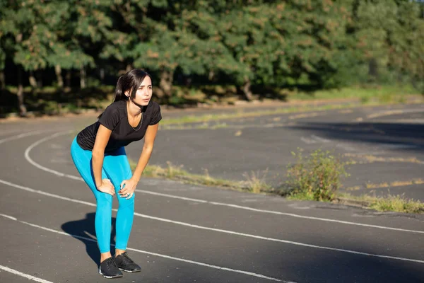 Atractiva morena corriendo a la luz del día en el trote — Foto de Stock