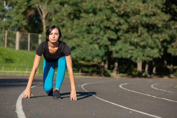 Ajuste corredor mujer en posición de partida listo para el sprint. Vaciar sp — Foto de Stock