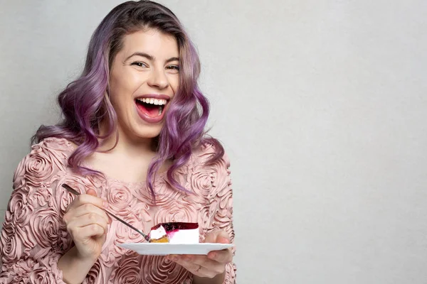 Lachend jong model met paars haar genieten van heerlijk dessert — Stockfoto