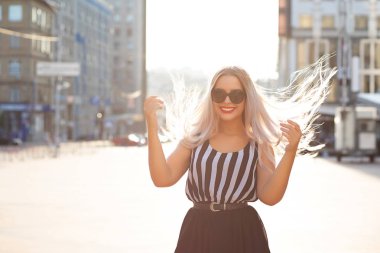 Yumuşak güneş lig ile saç poz rüzgar ile gülmek sarışın kadın