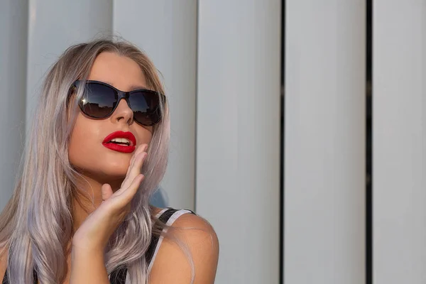 Glamor blonde girl with red lips wearing sunglasses posing near — Stock Photo, Image