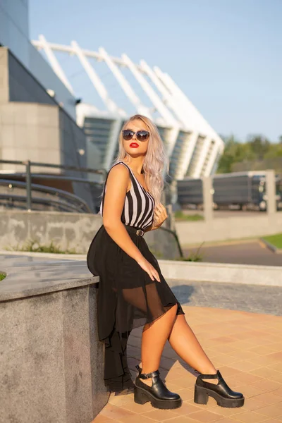 Ładna Blondynka ubrana w okulary i modny strój stwarzające w th — Zdjęcie stockowe
