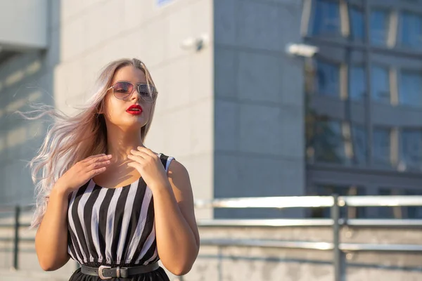 Attraktiv blond flicka med fladdrande hår bär glasögon posi — Stockfoto