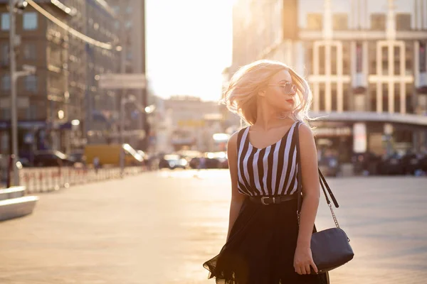 Stylowa blond kobieta z fruwające włosy stwarzające z wieczorem li — Zdjęcie stockowe