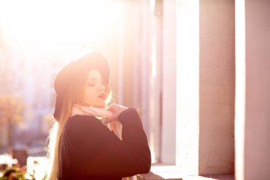 Eski stree poz ceket ve şapka giyen lüks sarışın model