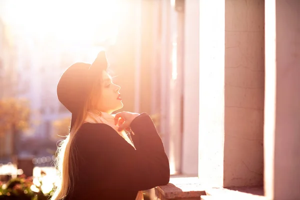 Glamorous blonde woman wearing coat and hat posing at the old st — Stock Photo, Image