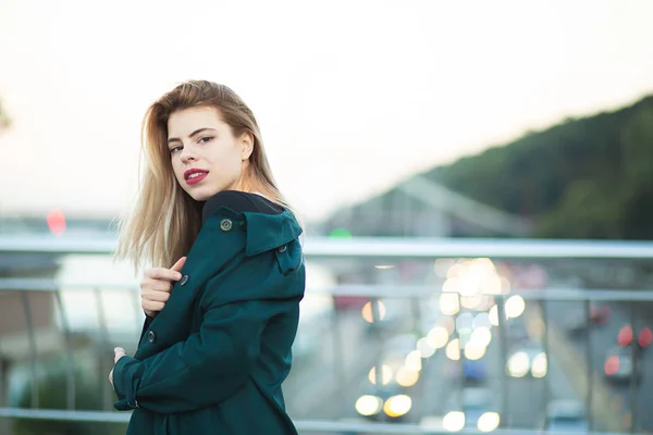 Schattige jonge vrouw dragen groene vacht poseren op de brug wit — Stockfoto