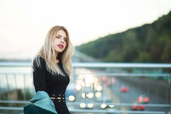 Prachtige jonge vrouw met groene jas poserend op de brug wi — Stockfoto