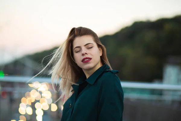 Fabulosa joven con abrigo verde posando en el puente con — Foto de Stock