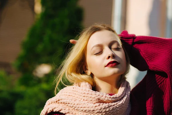 Elegant blonde model with red lips wearing pink knitted scarf po — Stock Photo, Image