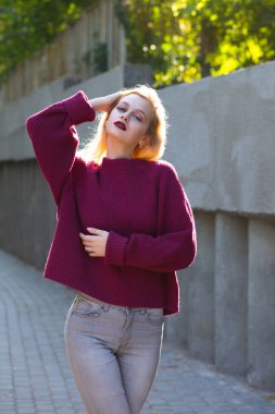 Kırmızı dudakları ile çekici sarışın model parkta poz böylece